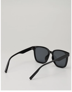 Vue latérale détaillée des lunettes de soleil noires surdimensionnées avec monture épaisse