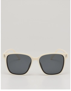 Détail de lunettes de soleil carrées oversize crème avec charnières en métal argenté