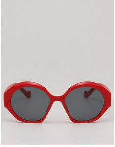 Dettaglio frontale di occhiali da sole vintage rossi ovali cat-eye con lenti scure donna