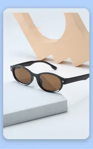 Detailed macro view of children's sunglasses with black oval frames and silver rivet accents