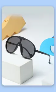 Detail of oversized black kids sunglasses with integrated nose pads on geometric props