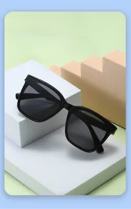 Détail de lunettes de soleil enfant carrées noires avec protection UV sur décor