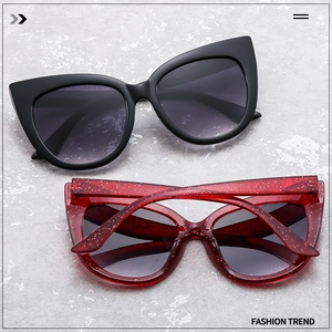 Detail of oversized cat eye sunglasses in matte black and sparkling glitter red resin