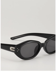 Close-up of black cat-eye sunglasses featuring silver metal side trim and triple rivets