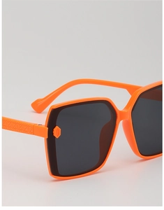 Detail of square children's sunglasses in orange and black with geometric textured temples
