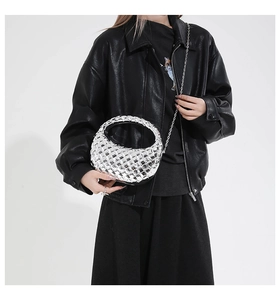 Silver woven evening bag with metallic mirror finish and chain strap on a model