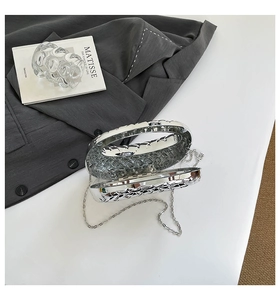 Detail view of silver hollow metal evening clutch with industrial chain strap design