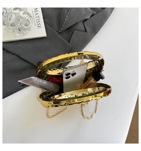 Detail of gold wavy evening bag showing interior space for phone and lipstick