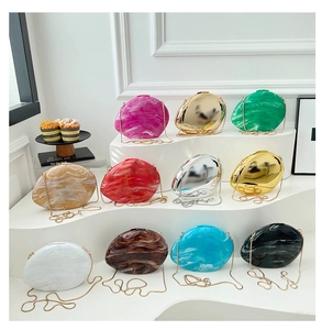 Collection of pebble-shaped evening clutch bags in metallic and marble finishes on a display