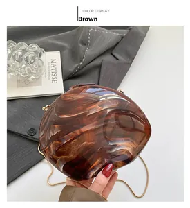 Close-up of brown marble textured shell evening clutch bag with golden chain strap