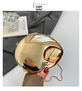 Detail of light gold shell clutch bag with mirror finish and slim snake chain strap