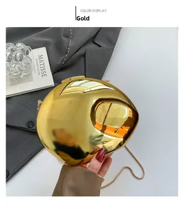 Detail of elegant gold shell evening clutch bag with metallic mirror finish and snake chain
