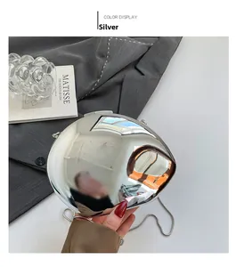 Close-up of a silver mirror acrylic clutch bag with futuristic pebble-shaped design