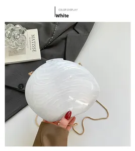 Macro shot of white marble texture acrylic evening bag with gold snake chain