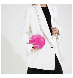 Detail of pink marble texture acrylic evening clutch with gold chain shoulder strap