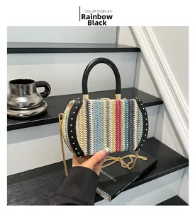 Rainbow striped woven straw bag with black round handles and gold stud details