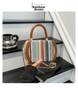 Close-up of rainbow straw bag with leather rivet trim and gold chain handle