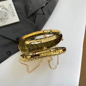 Elegant gold metallic evening bag with woven texture and chain strap in a premium setup