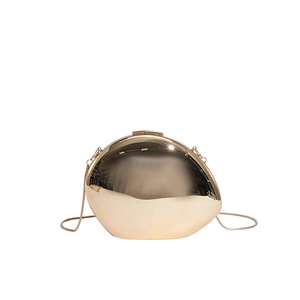 Close-up of golden egg-shaped evening bag featuring a mirror finish and metal chain