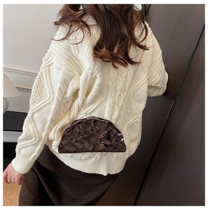 Brown metallic pleated cloud bag with gold chain strap shown on model's shoulder