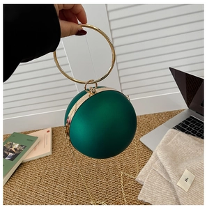 Detail of vintage dark green spherical evening bag with gold ring handle and chain