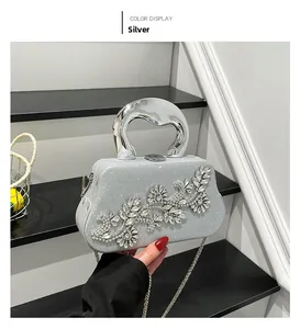 Close-up of silver evening bag with rhinestone flower cluster and metal handle