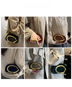 Plusieurs pochettes en velours avec strass et poignées dorées ovales sur le mannequin