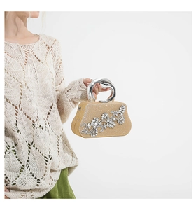 Close-up of golden glitter evening clutch featuring intricate rhinestone flower motifs