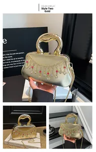 Détails de la pochette de soirée dorée avec franges en strass et accents de pierres rouges