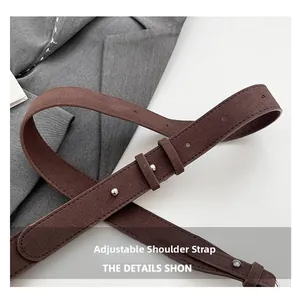 Détail de la bandoulière réglable en daim marron foncé avec attaches en métal argenté