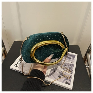 Détail du sac de soirée en velours vert foncé avec paillettes dorées et poignée