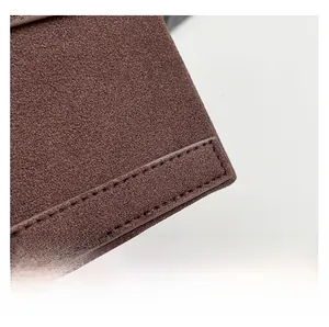 Gros plan détaillé de la texture en daim et des coutures précises du sac photo marron vintage
