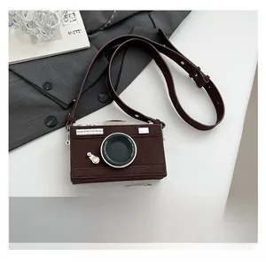 Détail du sac bandoulière en forme d'appareil photo en faux daim marron avec bandoulière