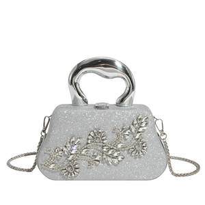 Macro detail of silver clutch featuring intricate floral rhinestone inlay and sequins