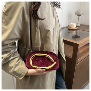 Détail du sac bandoulière en velours bordeaux avec strass et fermoir en métal doré