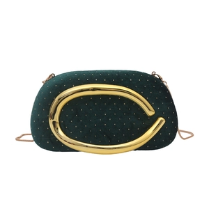 Détail du sac de soirée en velours vert avec pois dorés et poignée ronde en métal