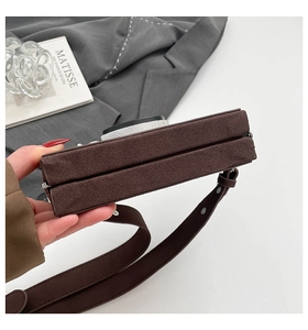 Détail du sac caméra vintage en daim marron avec fermeture éclair et bandoulière