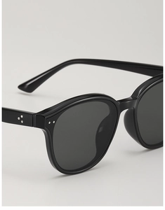 Macro detail of black acetate sunglasses frame featuring three silver metal rivets on the side