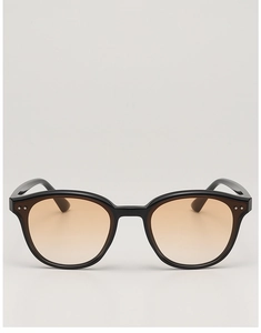 Detail of black sunglasses with amber lenses and dual silver rivet decorations