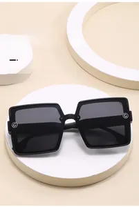 Detail of elegant black oversized square sunglasses with silver G-logo hinge decoration