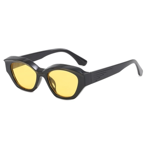 Occhiali da sole cat-eye neri con lenti gialle e aste con trama in rilievo alla moda