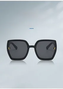 Detailed view of black oversized sunglasses featuring stylish gold metal hollow temples