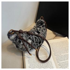 Detail of leopard print faux fur hobo bag with knotted brown leather strap and gold hardware