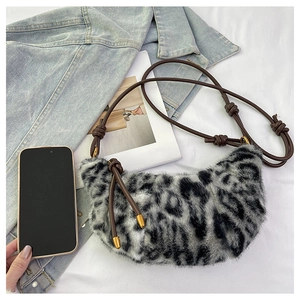 Detailed close-up of leopard print faux fur crescent bag with knotted rope strap