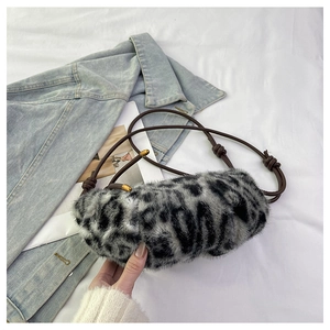 Detail of leopard print faux fur cylinder bag with thin brown strap and knot detail