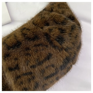 Macro shot of faux fur handbag featuring leopard animal print and soft plush texture