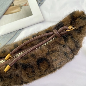 Plush leopard print faux fur handbag with golden zipper and leather knot detail