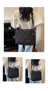 Detail of black quilted puffer bag showing side zipper pocket and adjustable strap