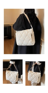 Detail of white quilted puffer shoulder bag featuring diamond lattice and wide strap