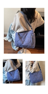 Detail of dark blue quilted nylon puffer bag with large diamond stitching and wide strap